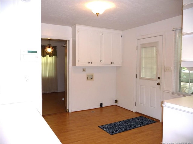 185 Meadow Rd, Lumberton, NC 28358 - clothes washing area featuring baseboards, a textured ceiling, cabinet space, light wood finished floors, and washer hookup
