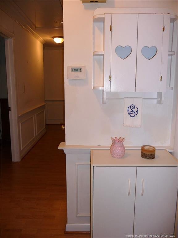 185 Meadow Rd, Lumberton, NC 28358 - kitchen featuring wainscoting, light countertops, white cabinets, dark wood-style floors, and a decorative wall