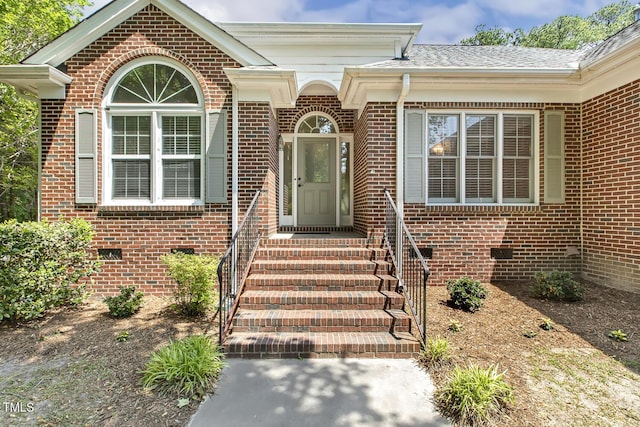 doorway to property featuring crawl space and brick siding