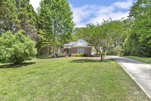 view of front of property with brick siding, a front lawn, and driveway