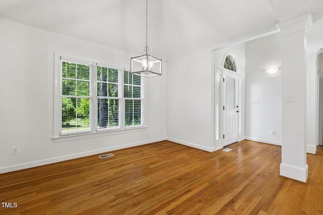 unfurnished dining area with visible vents, decorative columns, baseboards, and a chandelier