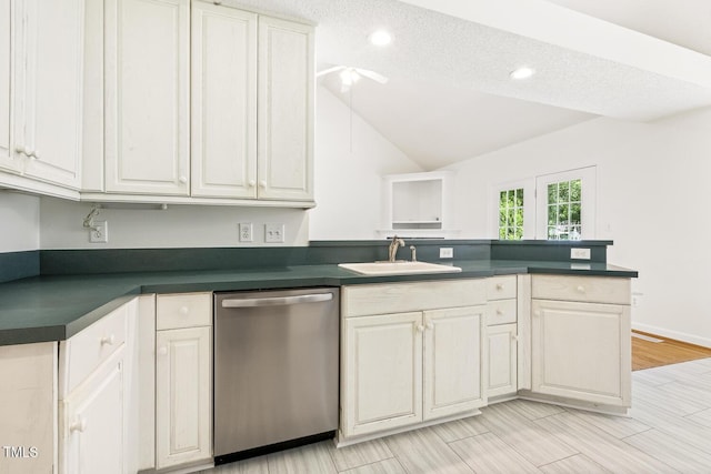 kitchen featuring dark countertops, dishwasher, a sink, a peninsula, and lofted ceiling