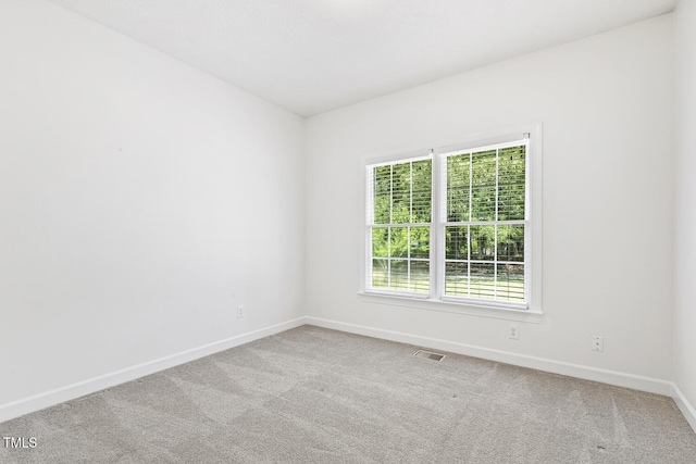 carpeted spare room with baseboards and visible vents