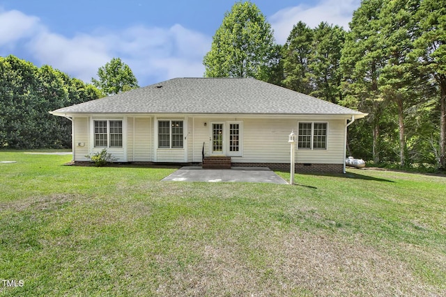 rear view of property with a lawn, entry steps, a patio area, and roof with shingles