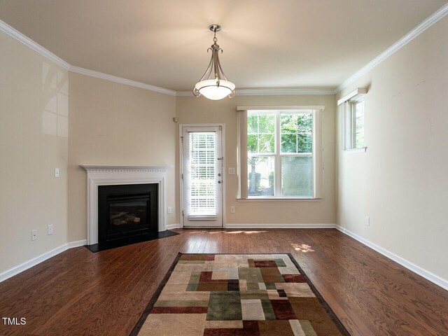 unfurnished living room featuring wood finished floors, ornamental molding, a fireplace with flush hearth, and baseboards
