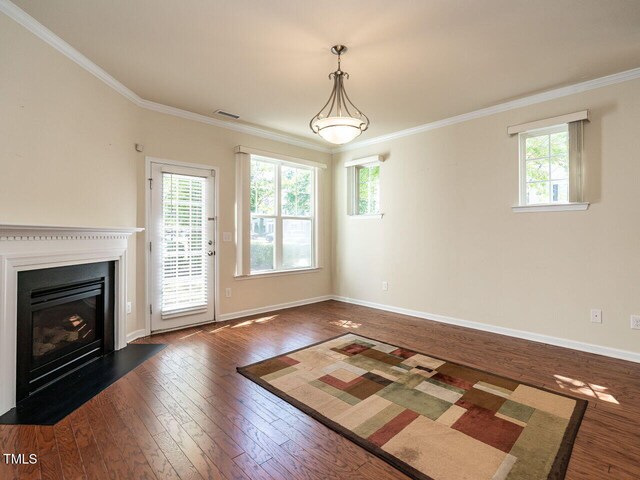 entryway featuring dark wood-type flooring, crown molding, plenty of natural light, a fireplace with flush hearth, and baseboards