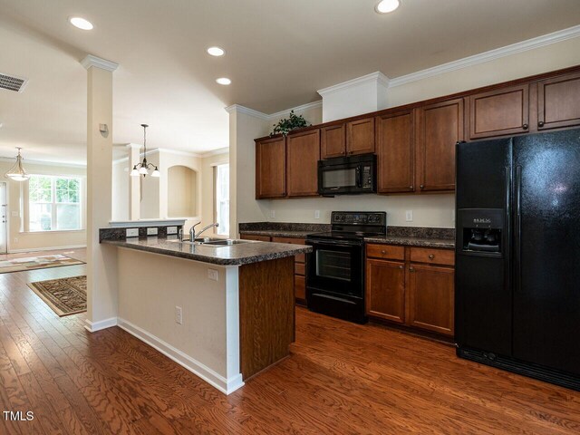 kitchen with black appliances, dark countertops, a sink, dark wood finished floors, and recessed lighting