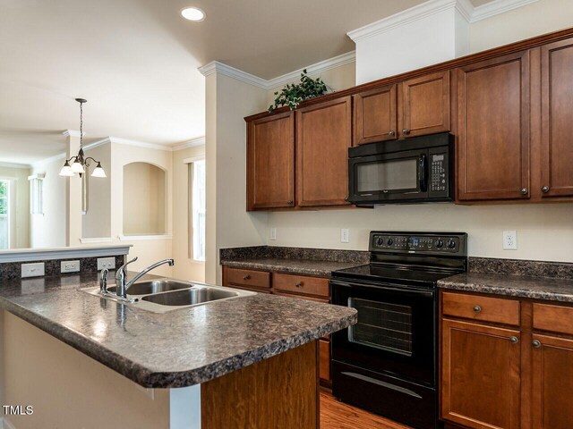 kitchen featuring black appliances, a sink, dark countertops, ornamental molding, and recessed lighting