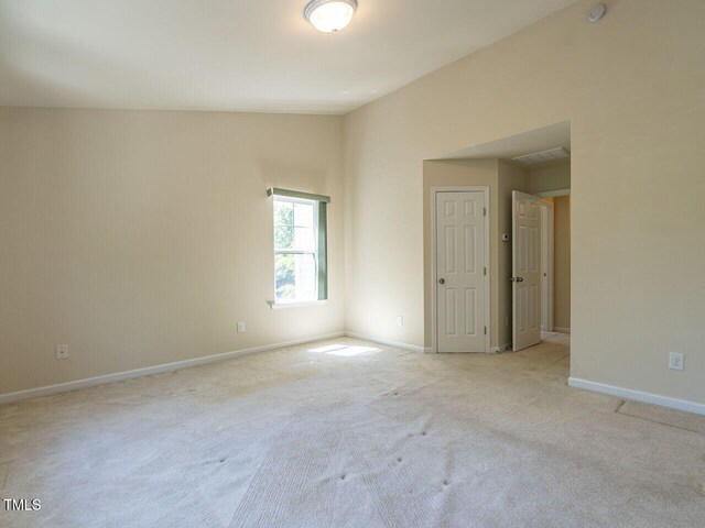 carpeted spare room featuring baseboards