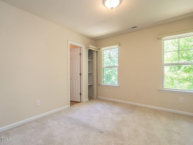 carpeted spare room featuring baseboards