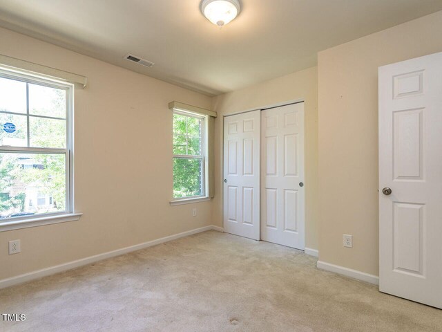 unfurnished bedroom featuring carpet, a closet, and baseboards