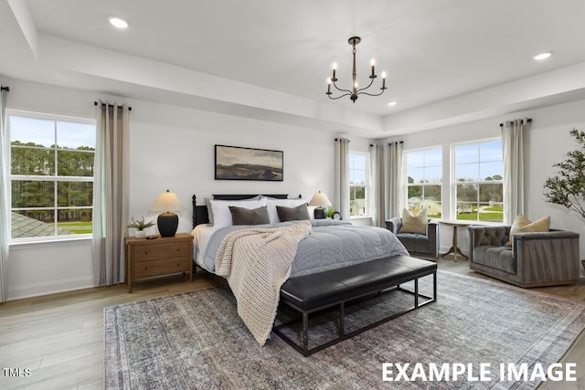15 Celtic Ln, Lillington, NC 27546 - bedroom featuring a notable chandelier, multiple windows, wood finished floors, and a raised ceiling