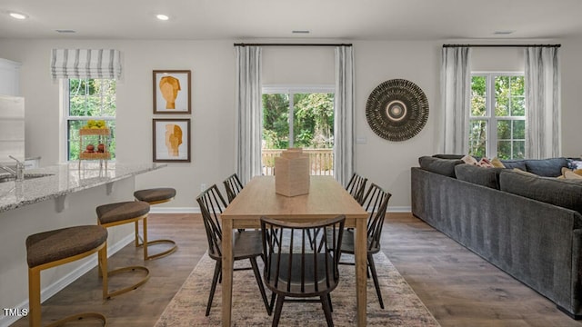dining room with baseboards, dark wood-type flooring, recessed lighting, and a wealth of natural light