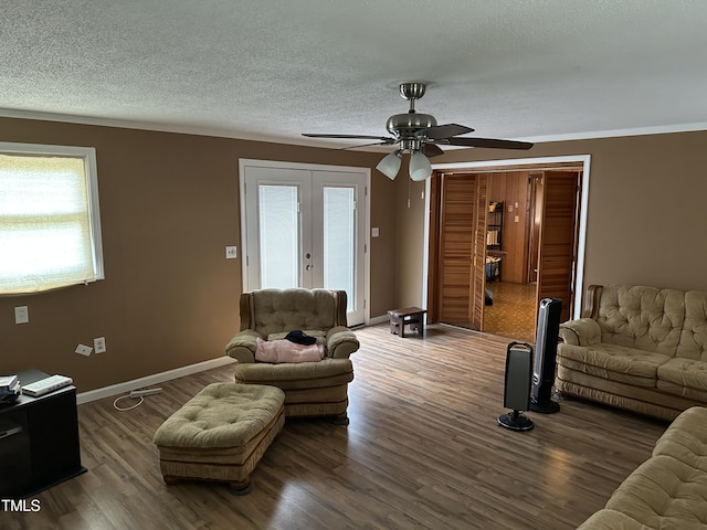 living area with a textured ceiling, french doors, a ceiling fan, baseboards, and wood finished floors