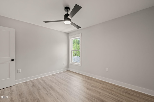 spare room featuring a ceiling fan, baseboards, and light wood-style flooring