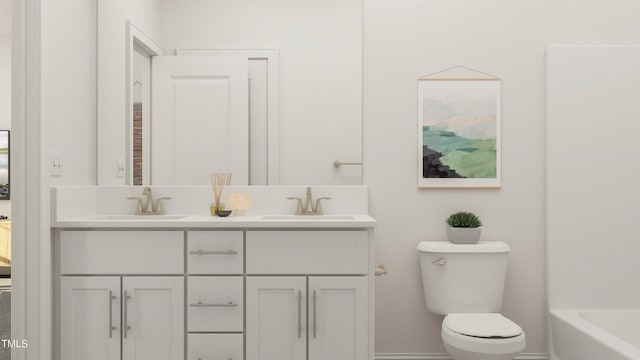 bathroom with double vanity, a sink, toilet, and a tub to relax in