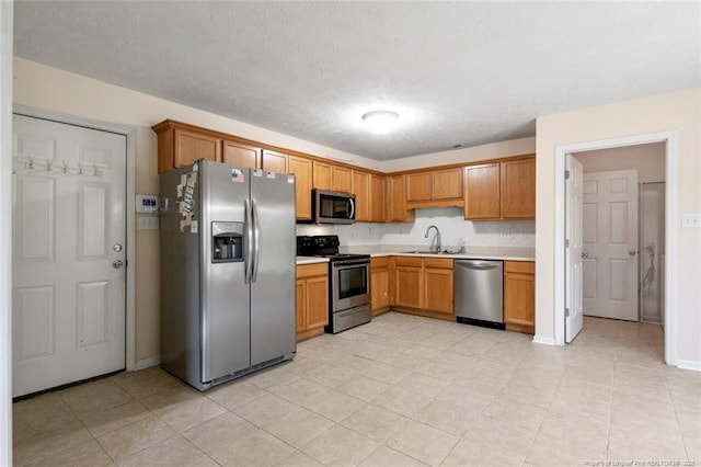 2495 Ohara Dr, Raeford, NC 28376 - kitchen with a sink, appliances with stainless steel finishes, baseboards, and light countertops