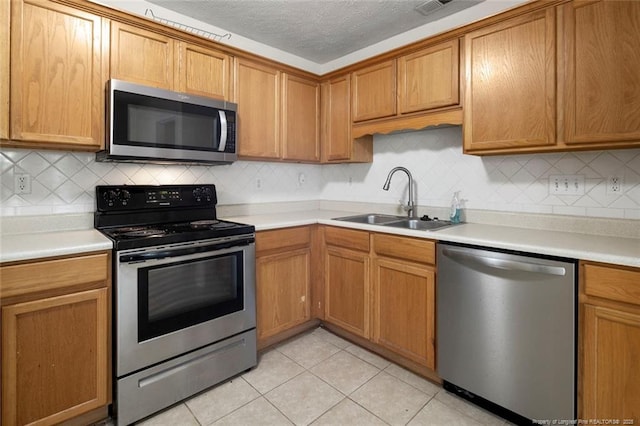 2495 Ohara Dr, Raeford, NC 28376 - kitchen featuring a sink, light countertops, backsplash, and stainless steel appliances