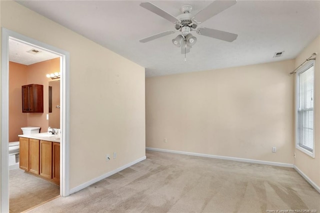 2495 Ohara Dr, Raeford, NC 28376 - spare room featuring visible vents, baseboards, ceiling fan, light colored carpet, and a sink