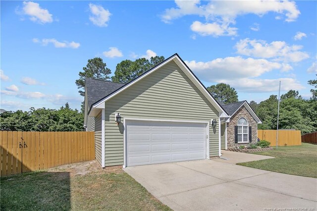 view of front of home featuring fence, a front yard, roof with shingles, an attached garage, and driveway