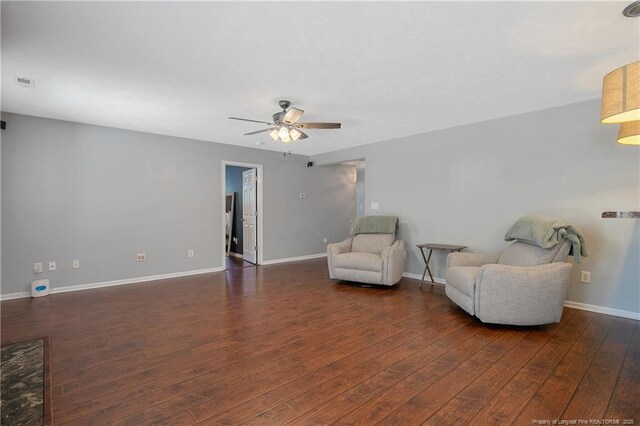 sitting room featuring baseboards, ceiling fan, visible vents, and wood finished floors