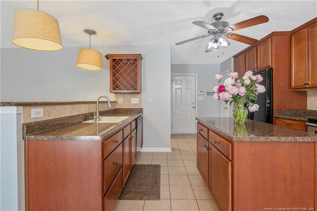 kitchen with stainless steel dishwasher, freestanding refrigerator, light tile patterned floors, a sink, and backsplash