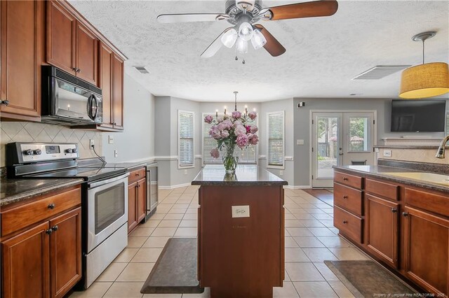 kitchen with dark countertops, black microwave, and stainless steel range with electric cooktop