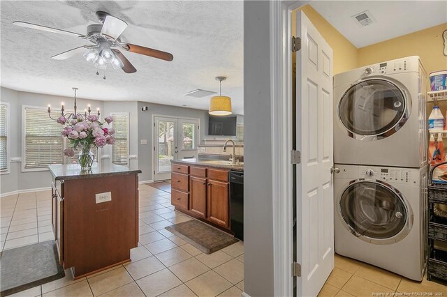 laundry room featuring ceiling fan, laundry area, stacked washing maching and dryer, a sink, and light tile patterned flooring