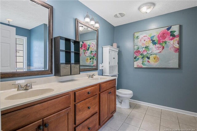 full bath with double vanity, baseboards, a sink, and tile patterned flooring