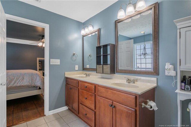 ensuite bathroom with a sink, tile patterned floors, ceiling fan, and connected bathroom