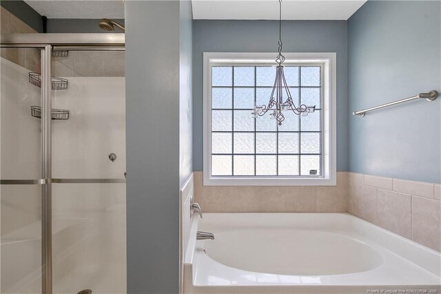 bathroom featuring a notable chandelier, a shower stall, and a healthy amount of sunlight