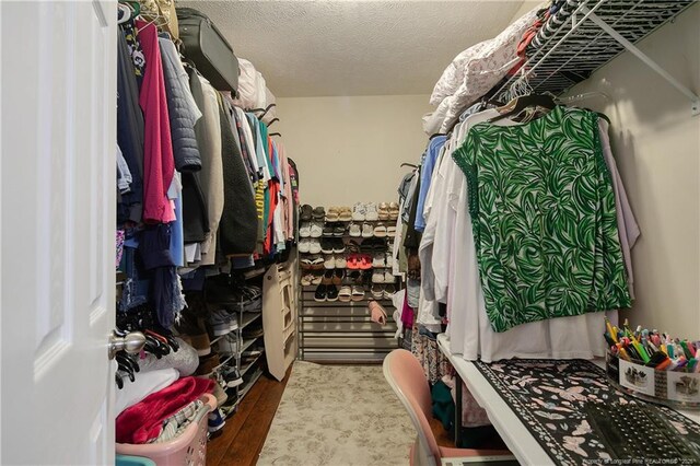 walk in closet with wood finished floors