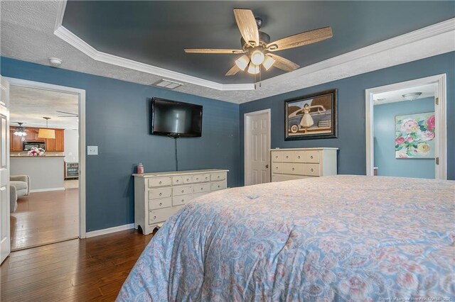 bedroom featuring baseboards, a ceiling fan, a tray ceiling, and dark wood-type flooring