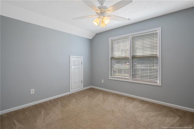 carpeted spare room with baseboards, ceiling fan, and lofted ceiling
