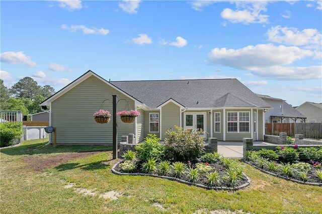 back of house featuring a lawn, fence, and a patio