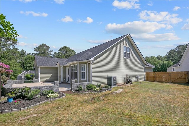 view of side of property featuring a lawn, a gate, a patio, and fence