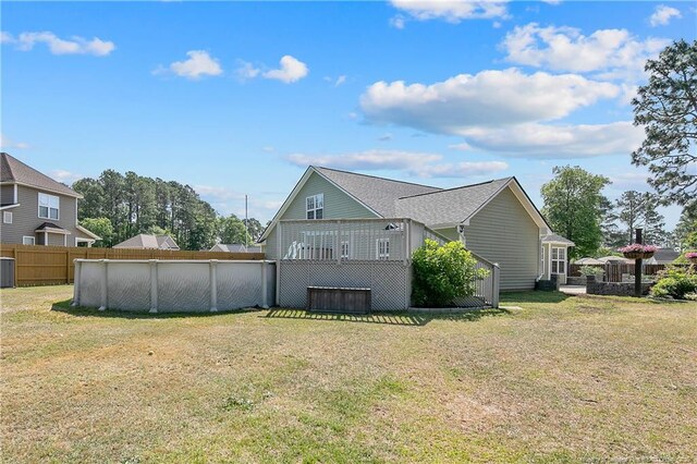 back of house with a fenced in pool, fence, and a yard