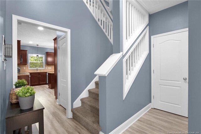 stairs with baseboards, recessed lighting, and wood finished floors