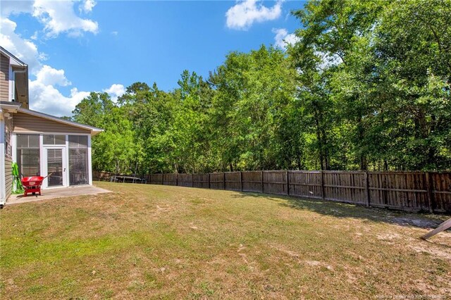 view of yard featuring a fenced backyard and a sunroom