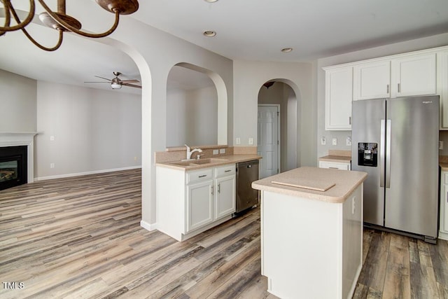 kitchen featuring appliances with stainless steel finishes, wood finished floors, a sink, light countertops, and recessed lighting