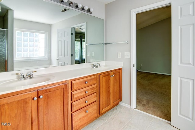 bathroom with double vanity, visible vents, a sink, and a shower with shower door