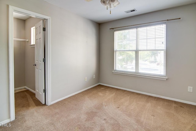 unfurnished room with visible vents, baseboards, carpet floors, and ceiling fan