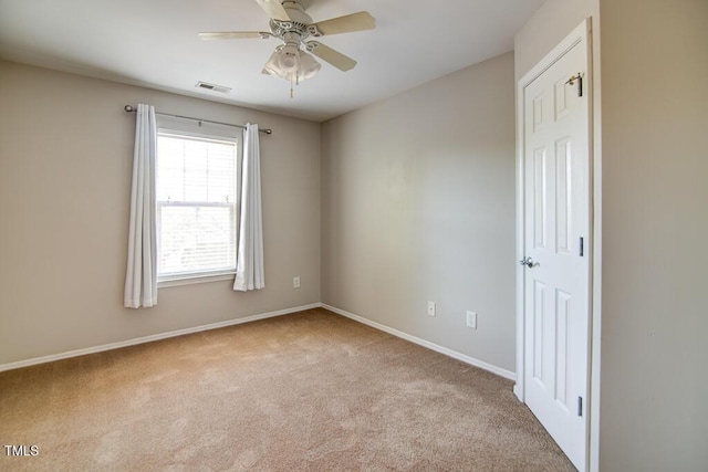 empty room with a ceiling fan, baseboards, visible vents, and carpet