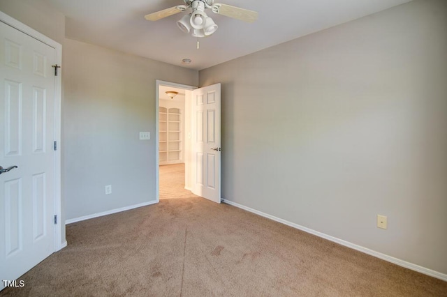 unfurnished bedroom featuring carpet floors, a ceiling fan, and baseboards