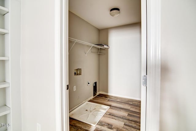 laundry room with laundry area, hookup for a washing machine, built in shelves, wood finished floors, and hookup for an electric dryer