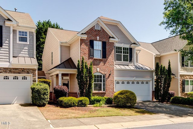 view of front of home with brick siding, a garage, driveway, and a standing seam roof