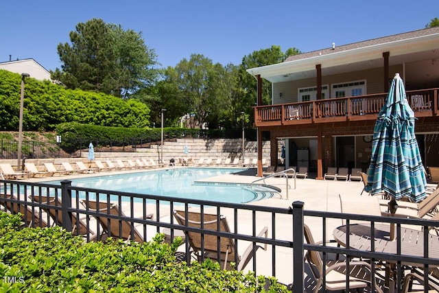 community pool featuring a patio and fence