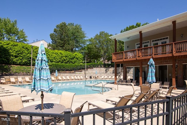community pool featuring fence and a patio area