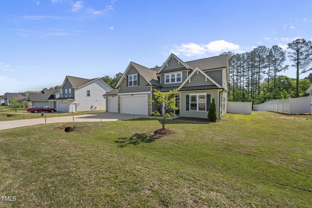 craftsman inspired home with a garage, a front lawn, fence, and concrete driveway