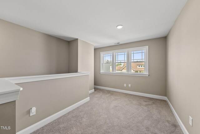 spare room with baseboards, carpet flooring, and visible vents
